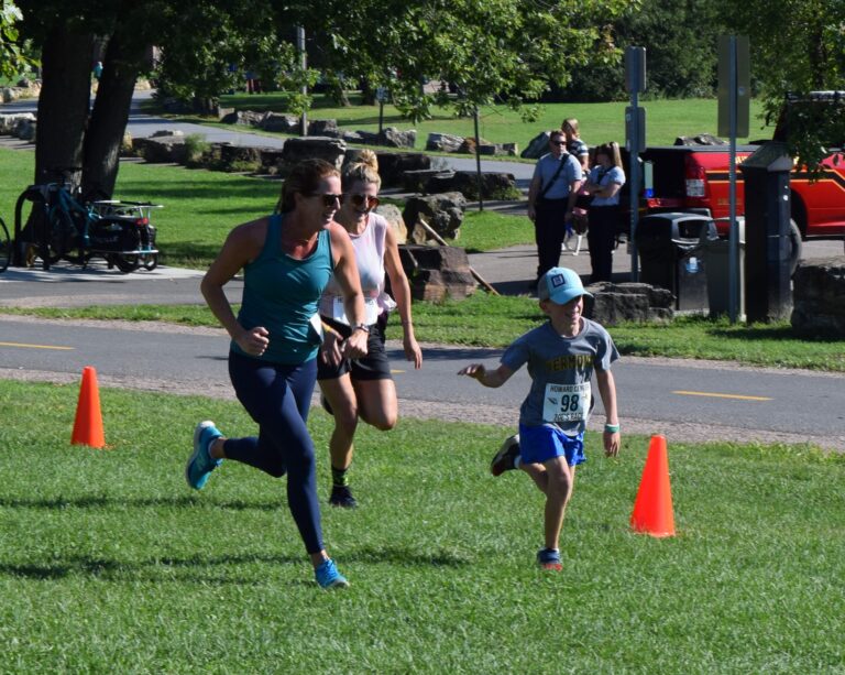 an adult and child running a race outdoors