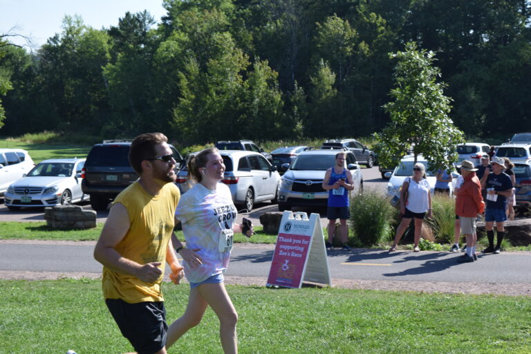 two adults running about to finish a 5k race