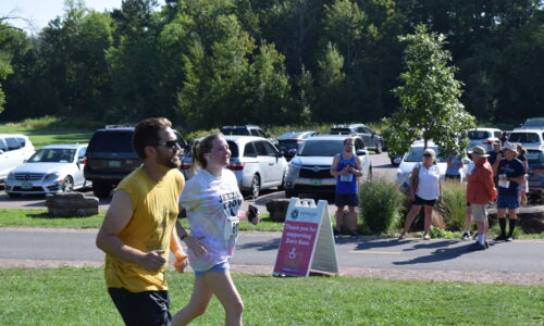 two adults running about to finish a 5k race