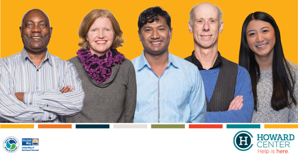 A diverse collection of Howard Center employees standing and smiling in front of a yellow background