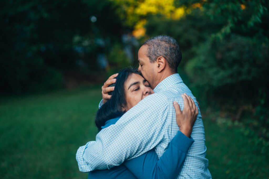 Two people embrace outdoors