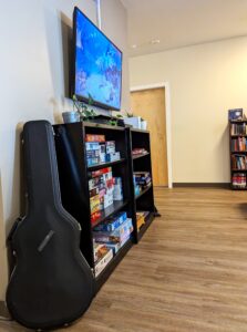 Guitar leans against entertainment center indoors.